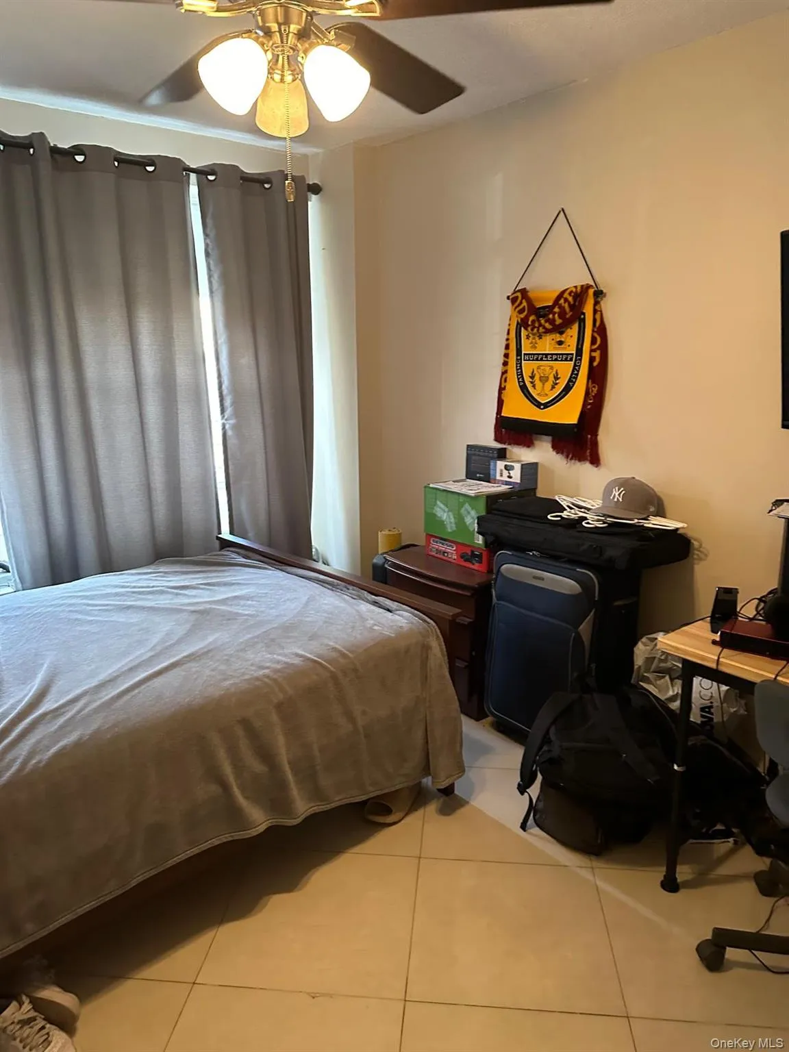 Bedroom featuring light tile patterned floors and a ceiling fan Bedroom featuring light tile patterned floors and a ceiling fan