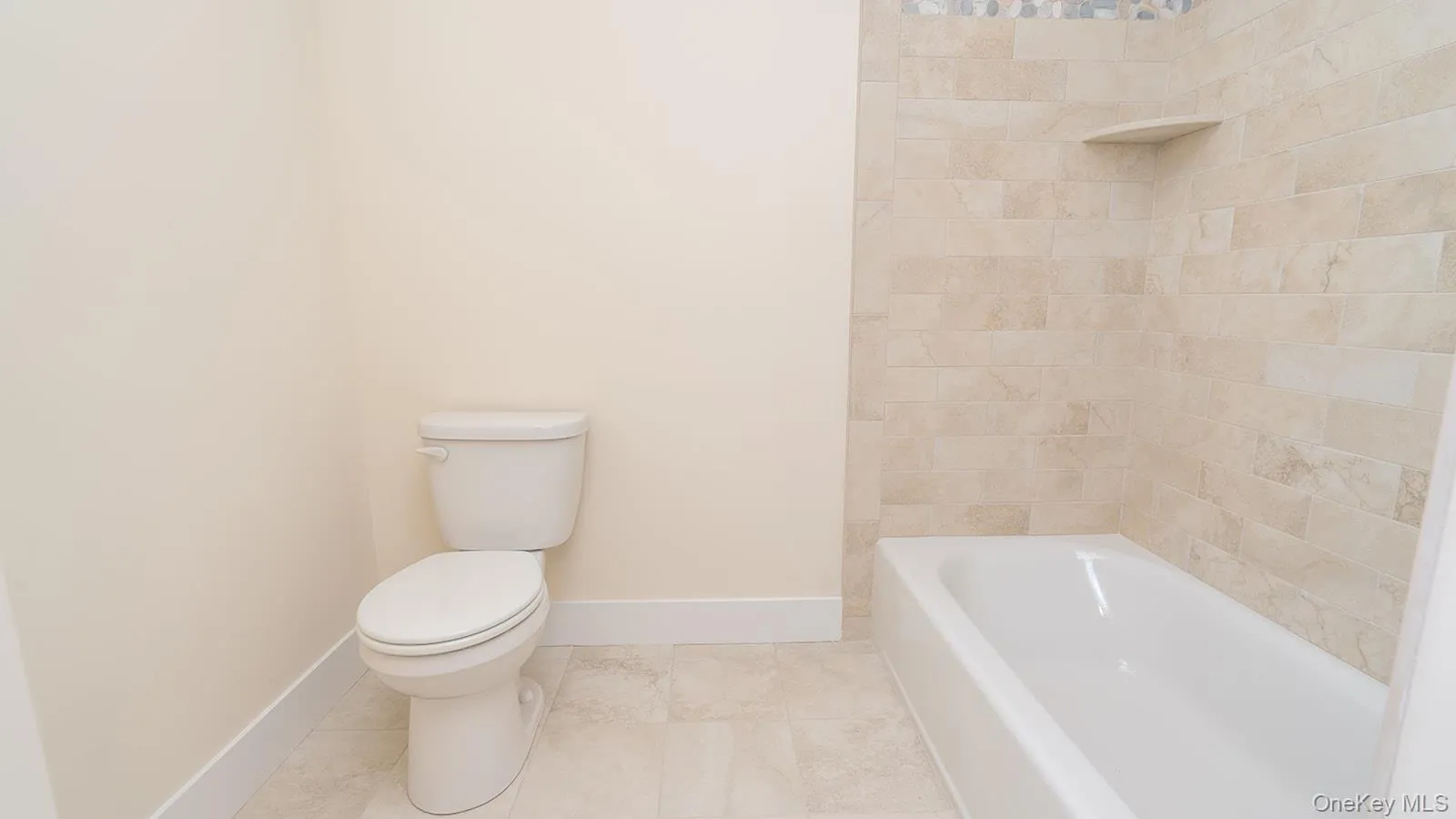 Full bath featuring shower / tub combination and tile patterned flooring Full bath featuring shower / tub combination and tile patterned flooring