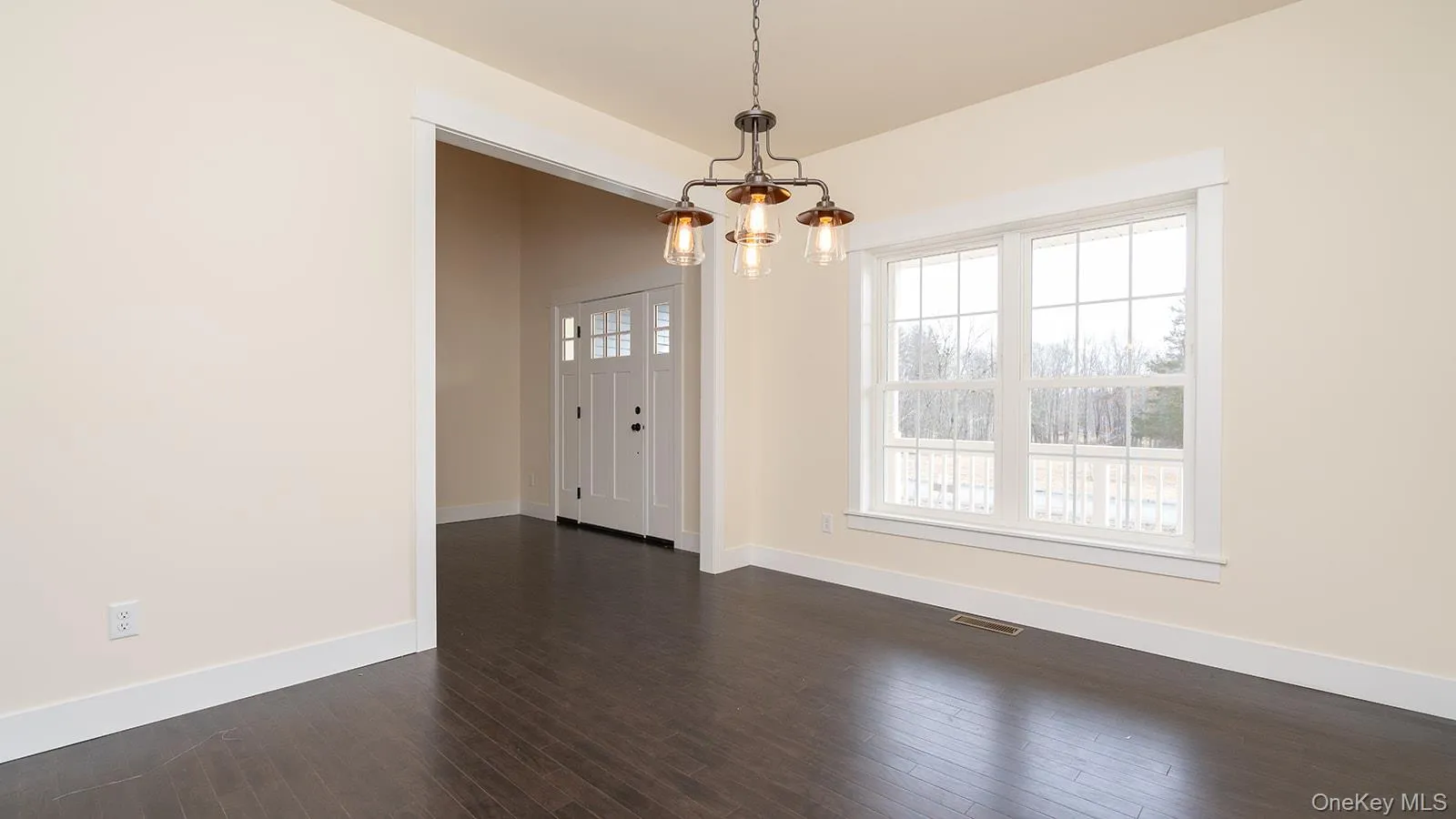 Unfurnished dining area with dark wood-style floors and a chandelier Unfurnished dining area with dark wood-style floors and a chandelier