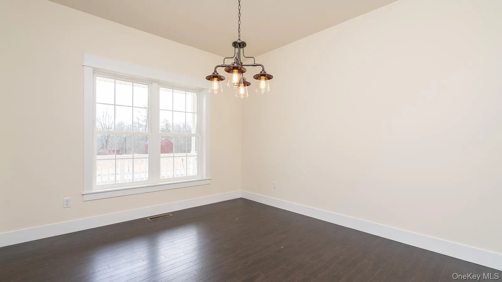 Spare room featuring dark wood-style flooring and a chandelier Spare room featuring dark wood-style flooring and a chandelier