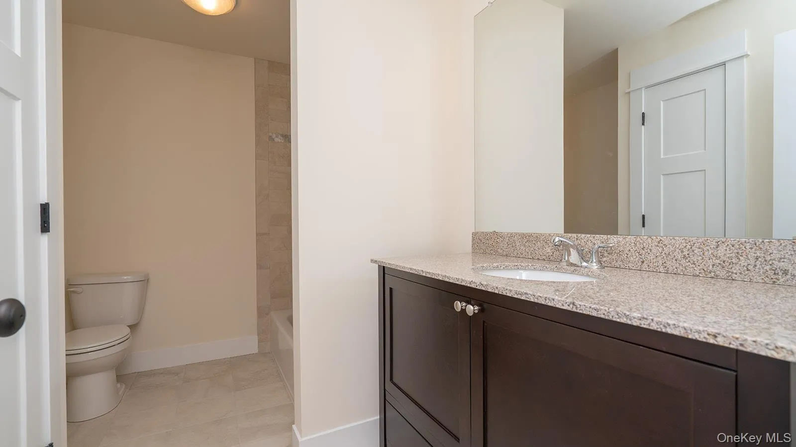 Bathroom with vanity, shower combination, and light tile patterned floors Bathroom with vanity, shower combination, and light tile patterned floors
