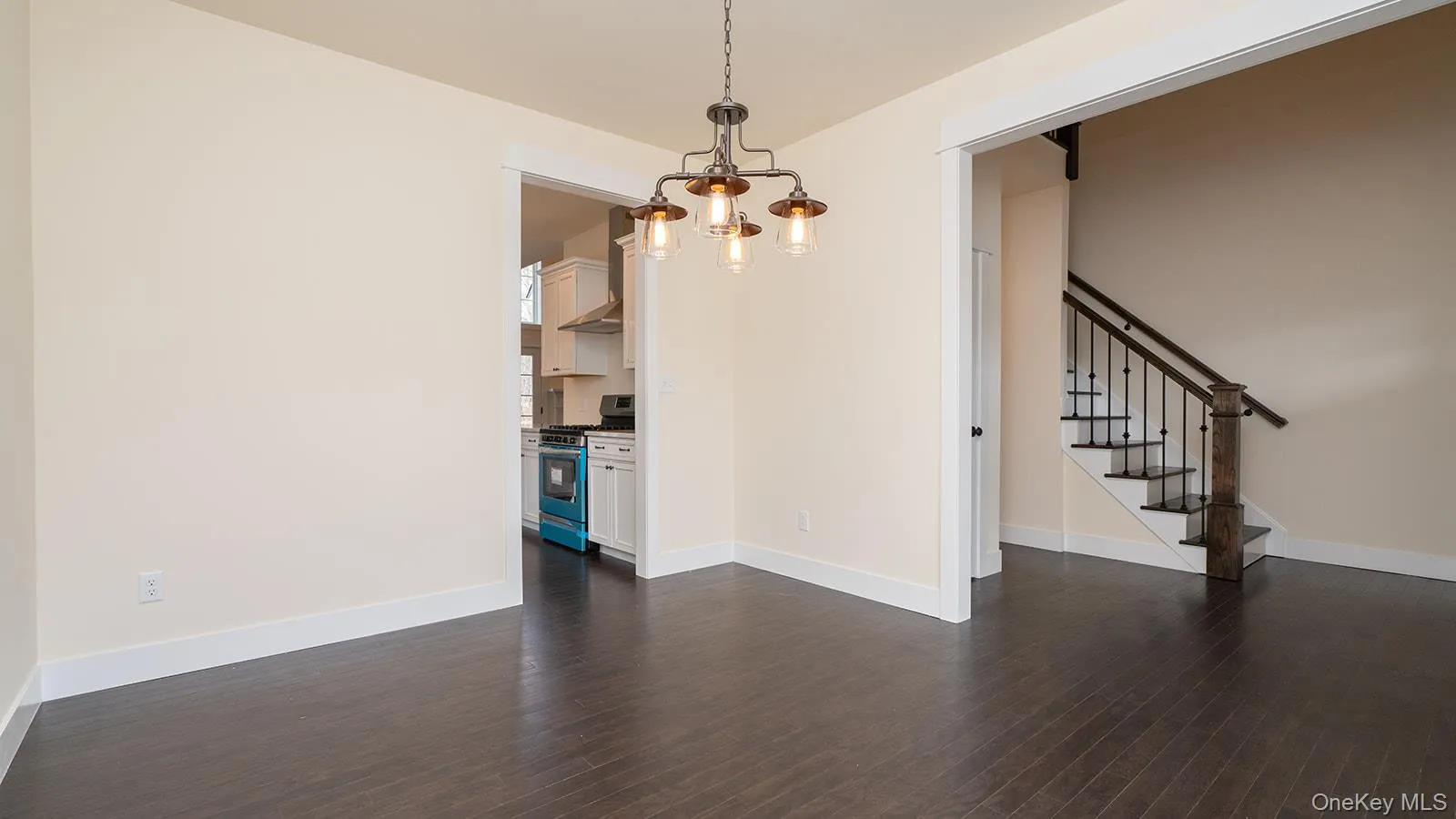 Unfurnished dining area featuring dark wood finished floors, a chandelier, and stairs Unfurnished dining area featuring dark wood finished floors, a chandelier, and stairs