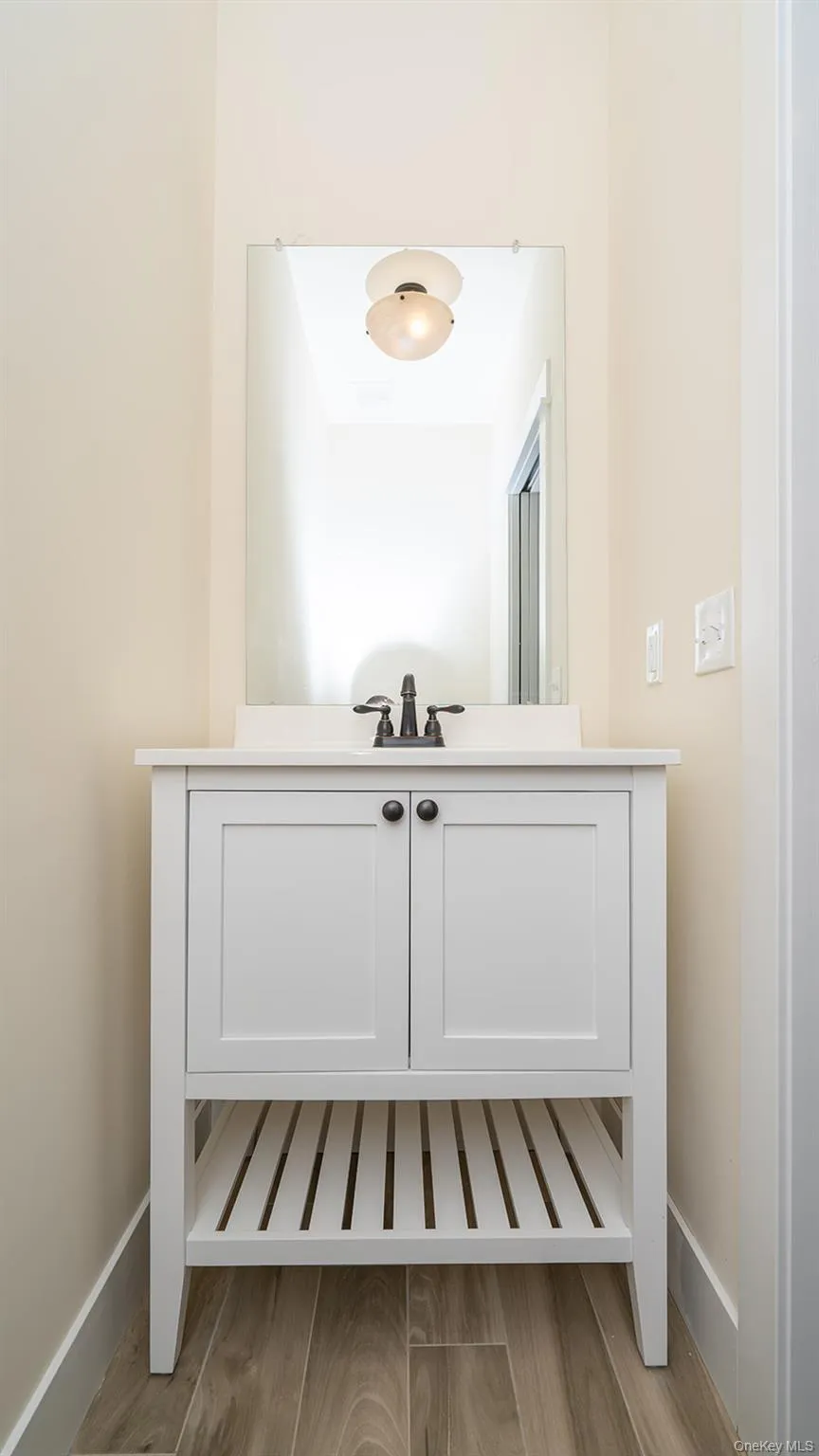 Half bathroom featuring vanity and light wood-type flooring Half bathroom featuring vanity and light wood-type flooring
