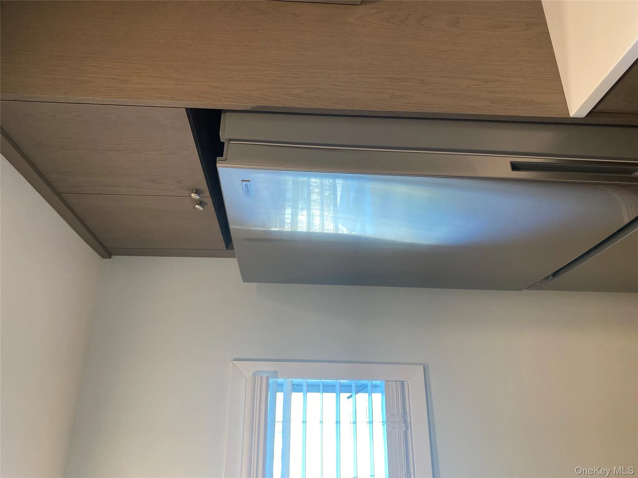 Kitchen with fridge, dark brown cabinetry, and light countertops Kitchen with fridge, dark brown cabinetry, and light countertops