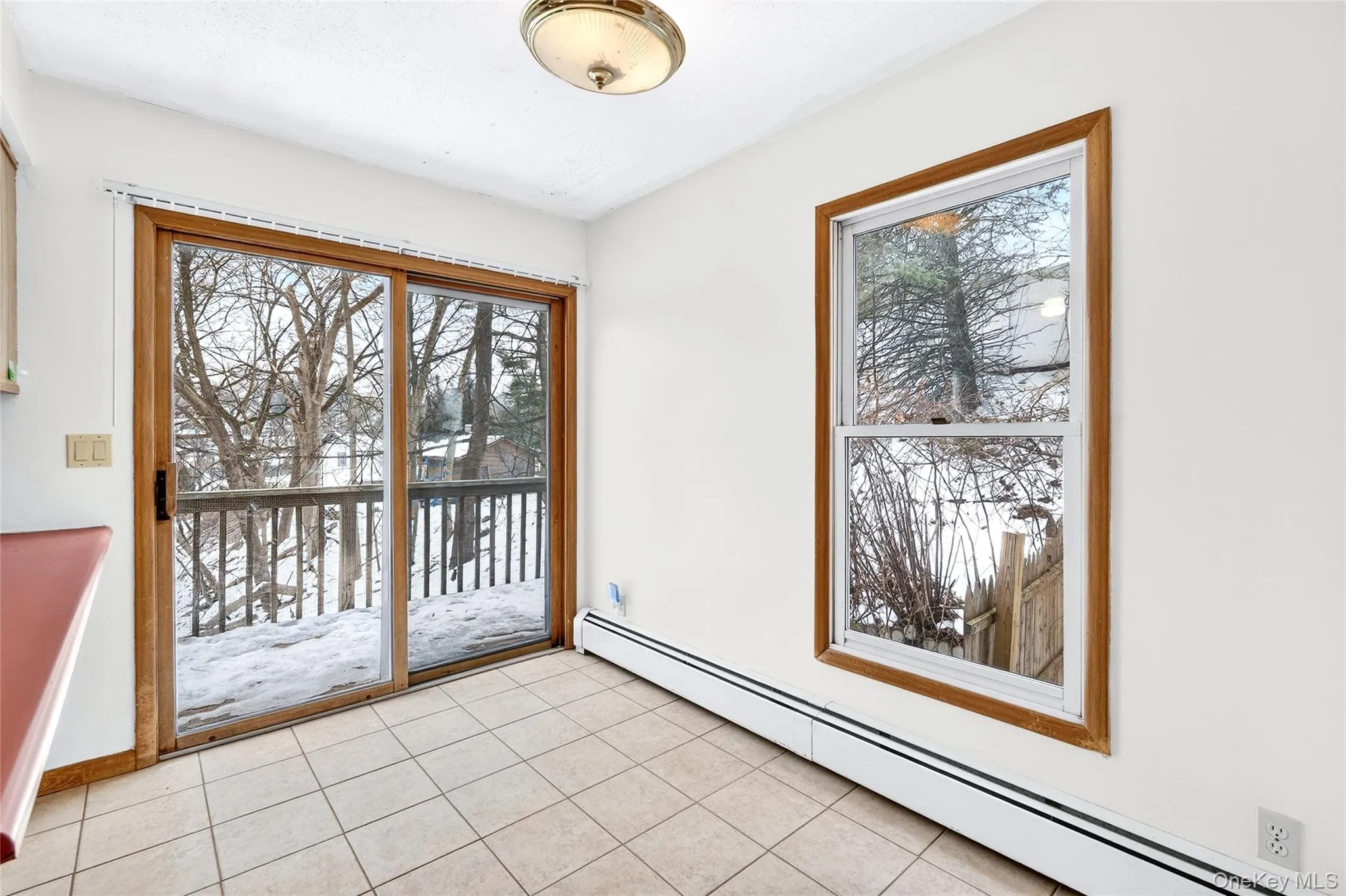 Doorway to outside featuring a baseboard radiator, tile patterned floors, and healthy amount of natural light Doorway to outside featuring a baseboard radiator, tile patterned floors, and healthy amount of natural light