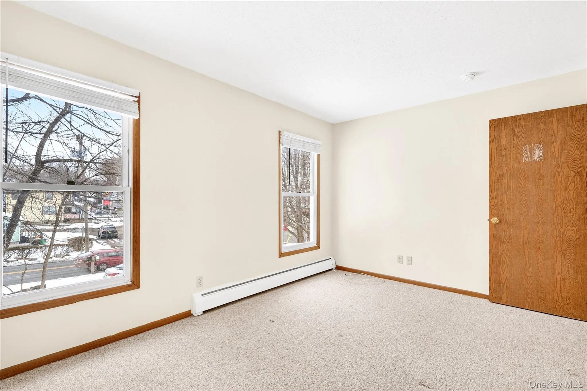 Carpeted spare room with a baseboard radiator and baseboards Carpeted spare room with a baseboard radiator and baseboards