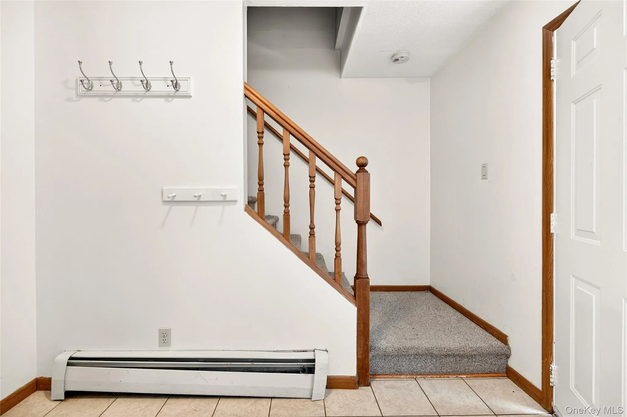 Stairs with a baseboard heating unit and tile patterned floors Stairs with a baseboard heating unit and tile patterned floors