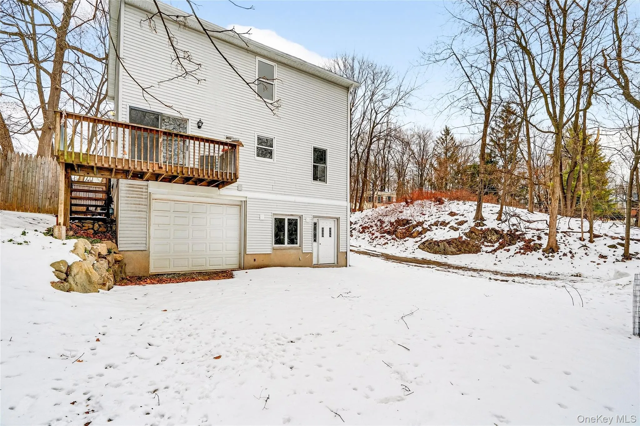 Snow covered back of property featuring a garage Snow covered back of property featuring a garage