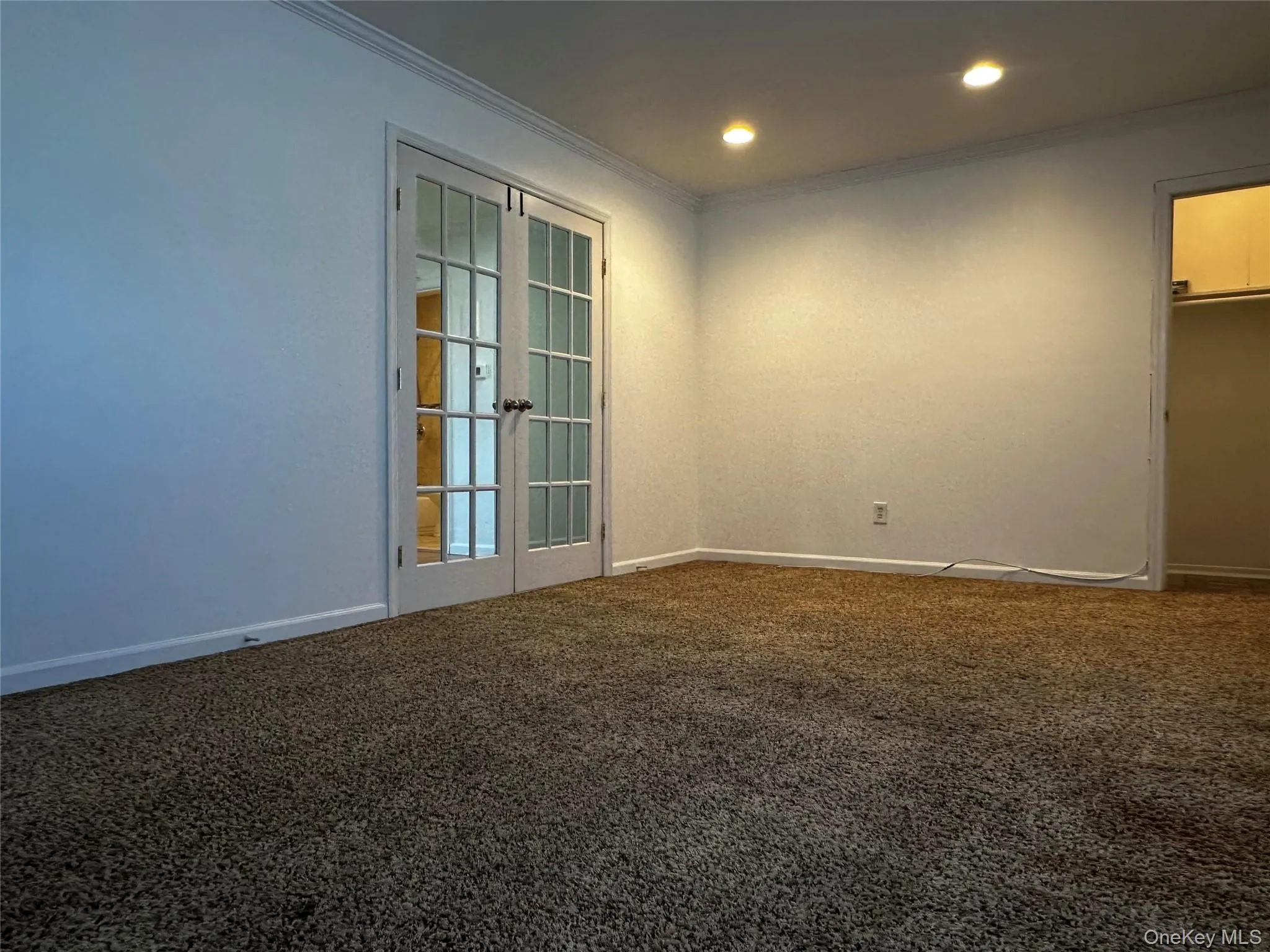 Living room with french doors, carpet, crown molding, and recessed lighting Living room with french doors, carpet, crown molding, and recessed lighting