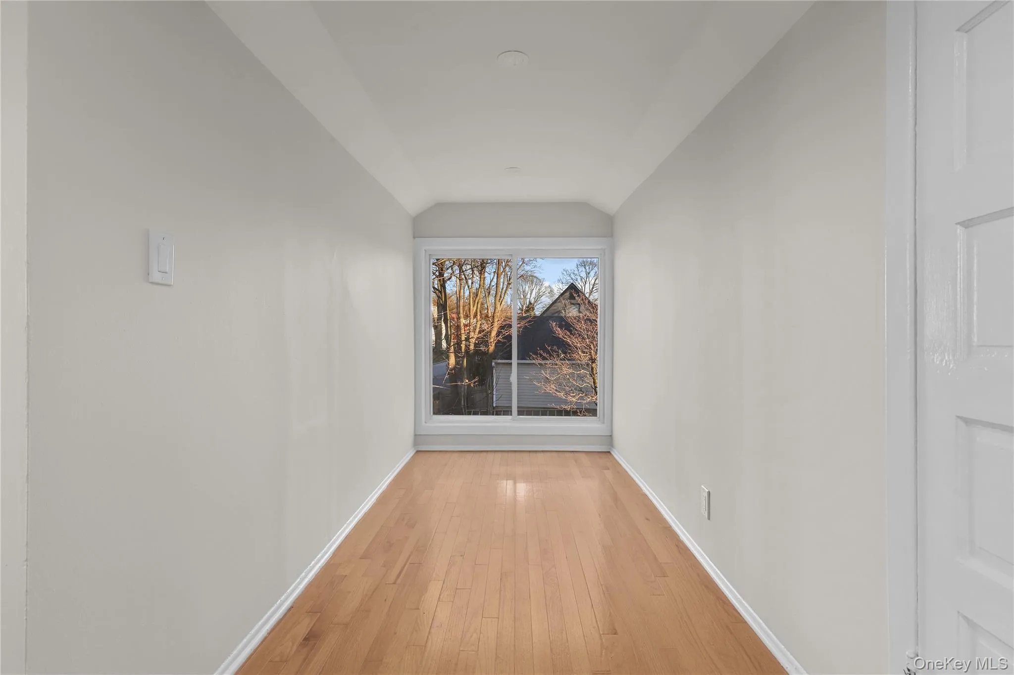 Hallway featuring hardwood / wood-style flooring and vaulted ceiling Hallway featuring hardwood / wood-style flooring and vaulted ceiling