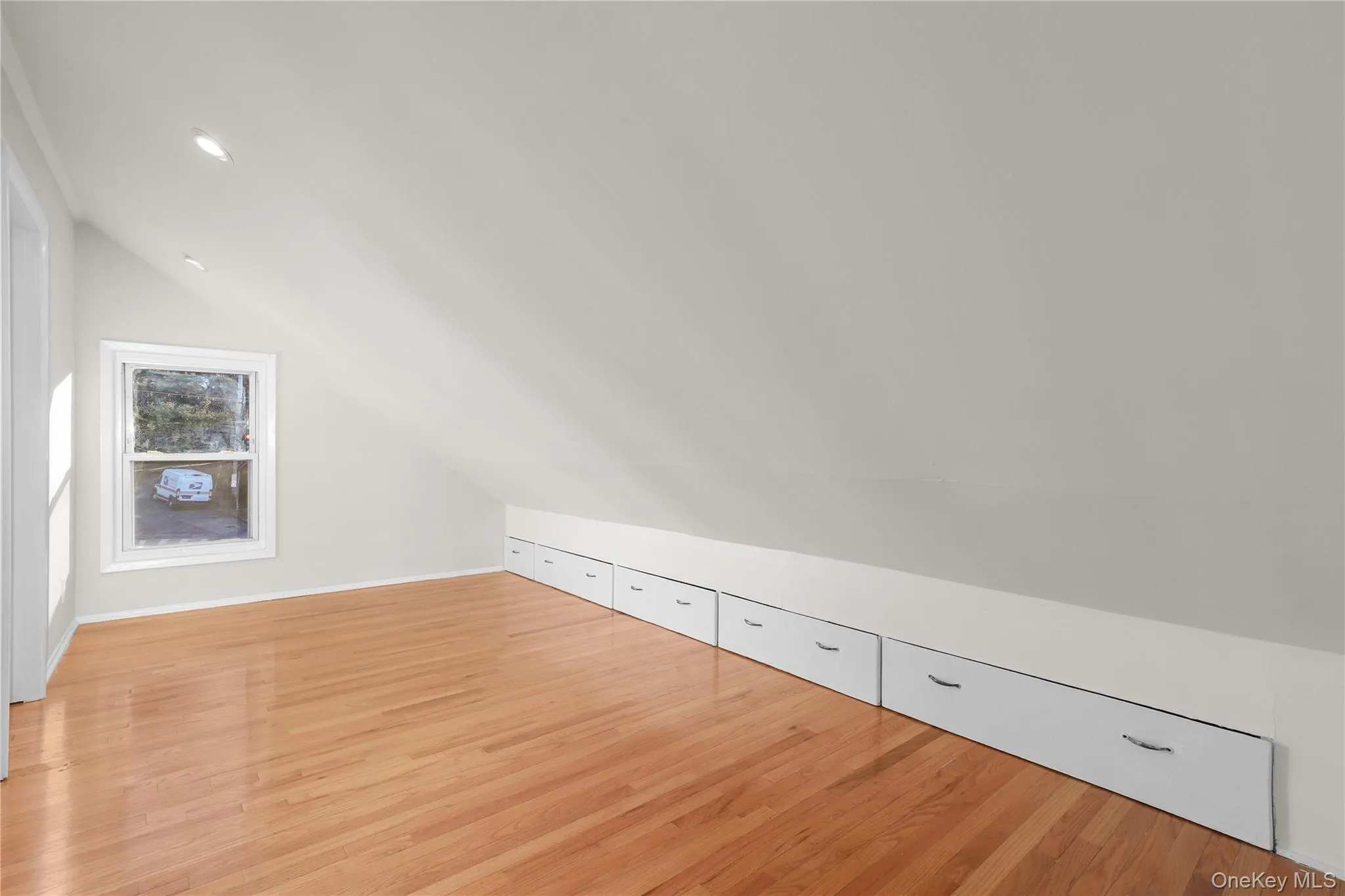 Additional living space with light wood finished floors and vaulted ceiling Additional living space with light wood finished floors and vaulted ceiling