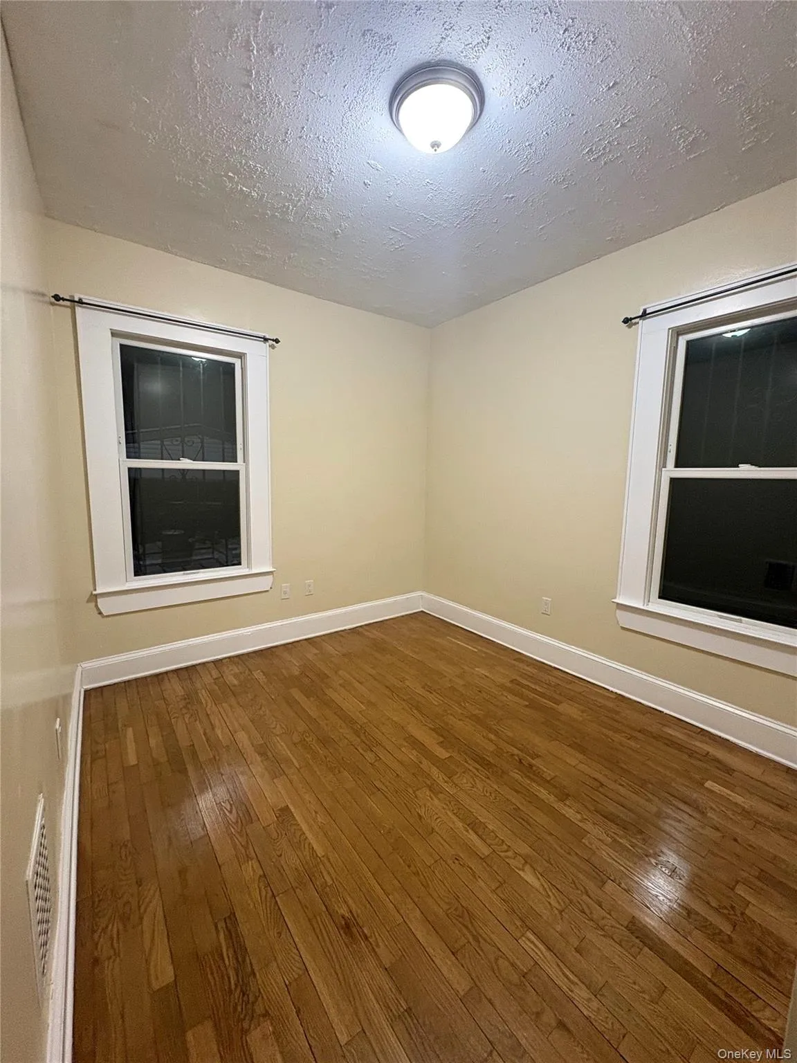 Bright bedroom with hardwood floor,fresh paint,and two windows providing good natural light. Bright bedroom with hardwood floor,fresh paint,and two windows providing good natural light.