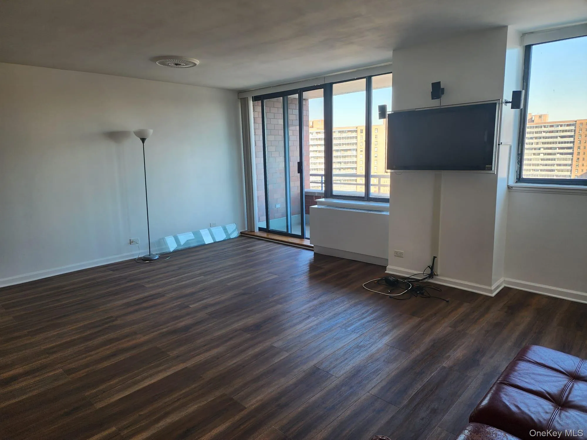 Unfurnished living room with dark wood-style flooring and baseboards Unfurnished living room with dark wood-style flooring and baseboards