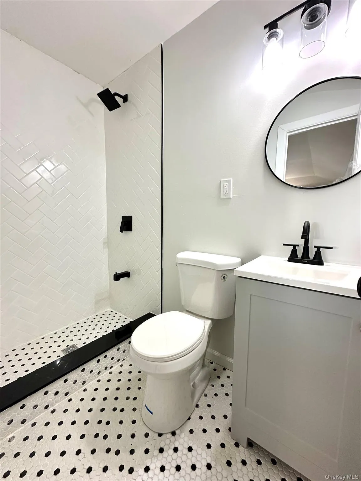 Bathroom with a stall shower, vanity, and light tile patterned floors Bathroom with a stall shower, vanity, and light tile patterned floors