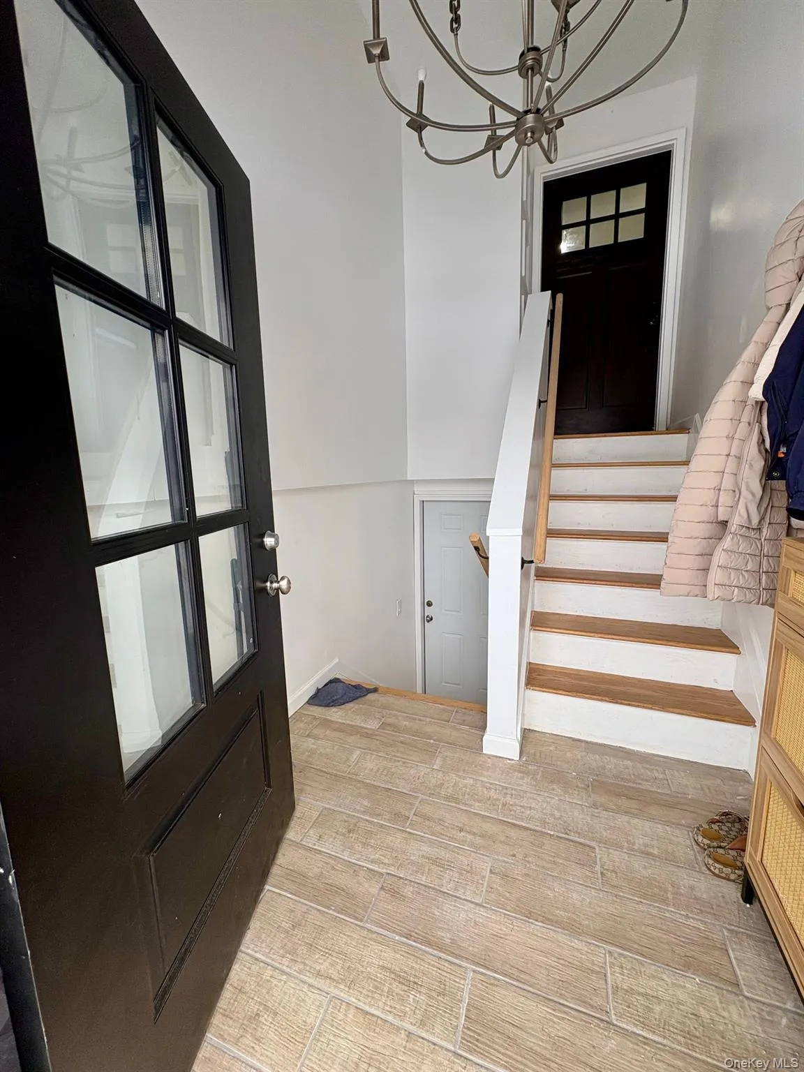 Entrance foyer featuring wood finish floors, a chandelier, and stairway Entrance foyer featuring wood finish floors, a chandelier, and stairway