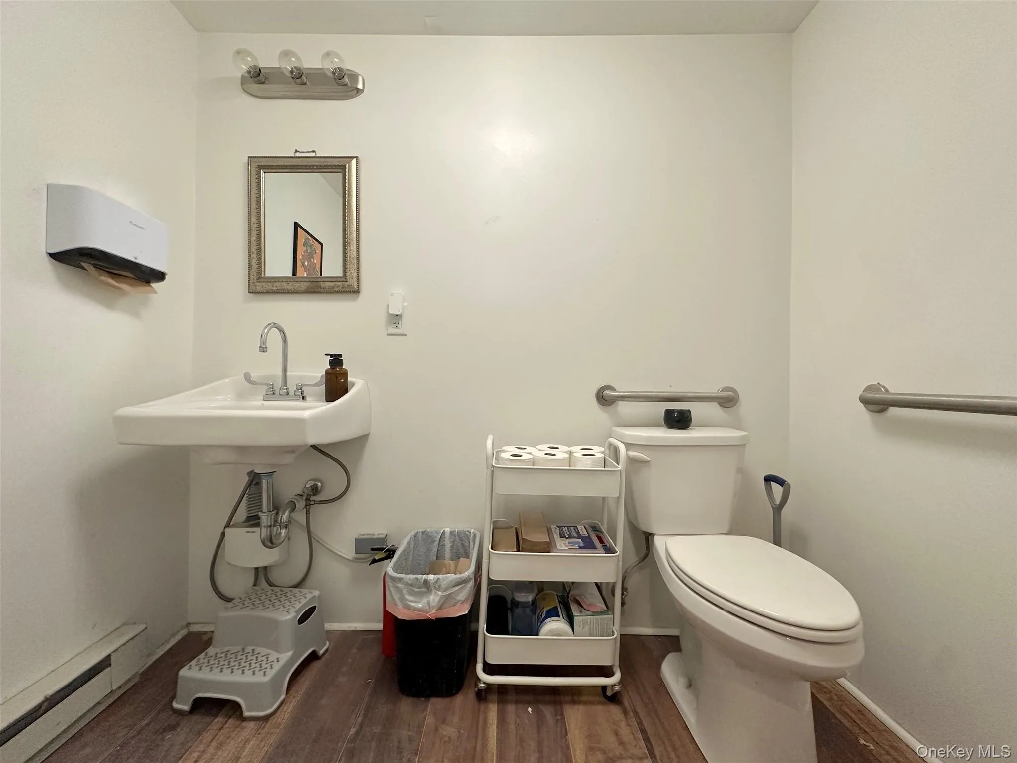 Bathroom with a baseboard heating unit and dark wood-type flooring Bathroom with a baseboard heating unit and dark wood-type flooring