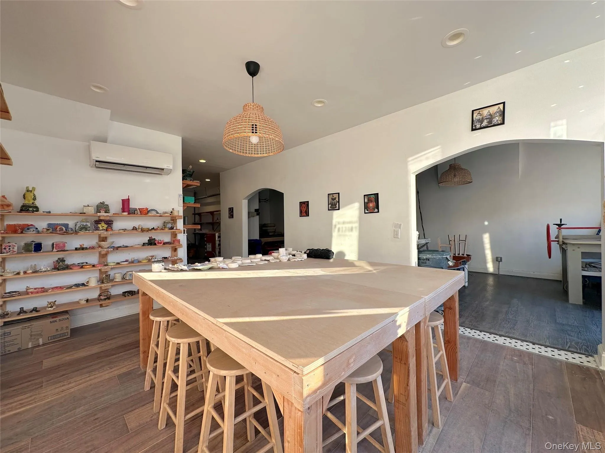 Kitchen featuring dark wood-type flooring, arched walkways, hanging light fixtures, a wall unit AC, and recessed lighting Kitchen featuring dark wood-type flooring, arched walkways, hanging light fixtures, a wall unit AC, and recessed lighting