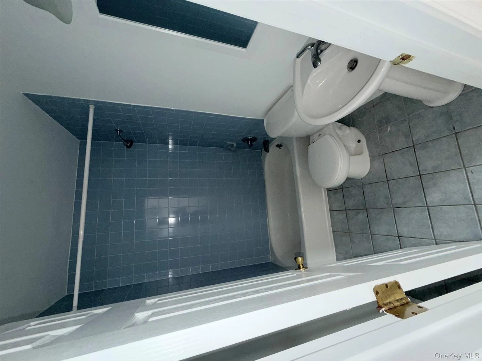 Full bath with dark tile patterned flooring and shower / bath combination Full bath with dark tile patterned flooring and shower / bath combination