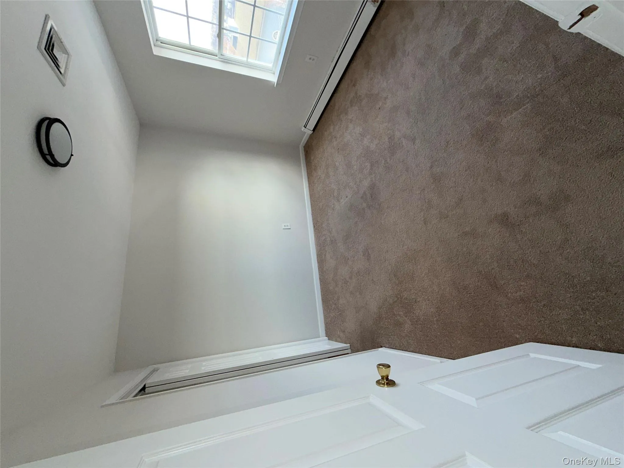 Carpeted spare room with a baseboard radiator and baseboards Carpeted spare room with a baseboard radiator and baseboards