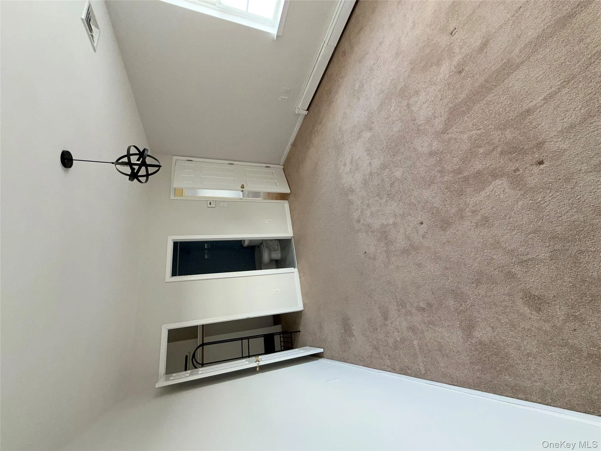 Unfurnished bedroom with a spacious closet, a baseboard heating unit, light carpet, and ensuite bathroom Unfurnished bedroom with a spacious closet, a baseboard heating unit, light carpet, and ensuite bathroom