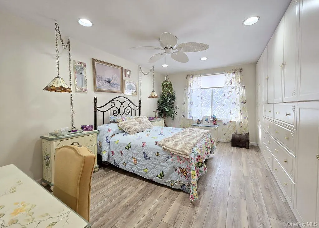 Bedroom with light wood-style flooring, ceiling fan, and recessed lighting Bedroom with light wood-style flooring, ceiling fan, and recessed lighting