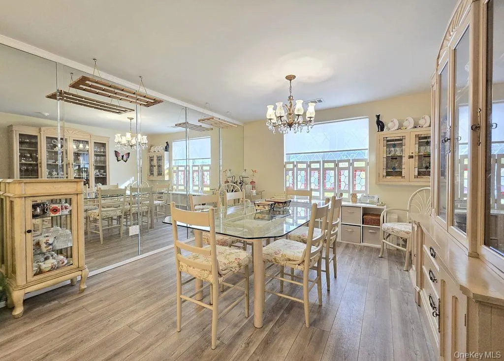 Dining area featuring light wood finished floors and a chandelier Dining area featuring light wood finished floors and a chandelier