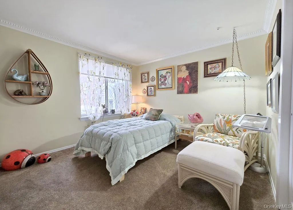 Carpeted bedroom with ornamental molding and baseboards Carpeted bedroom with ornamental molding and baseboards