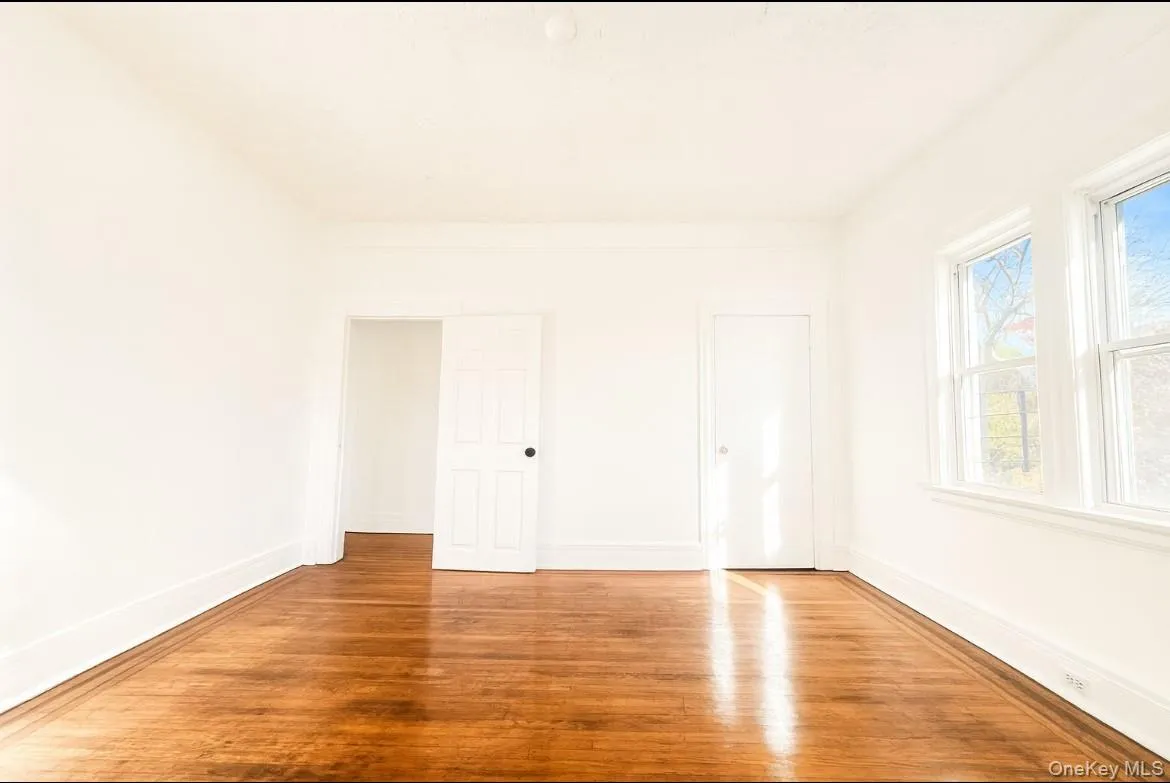 Unfurnished bedroom featuring hardwood / wood-style floors and baseboards Unfurnished bedroom featuring hardwood / wood-style floors and baseboards