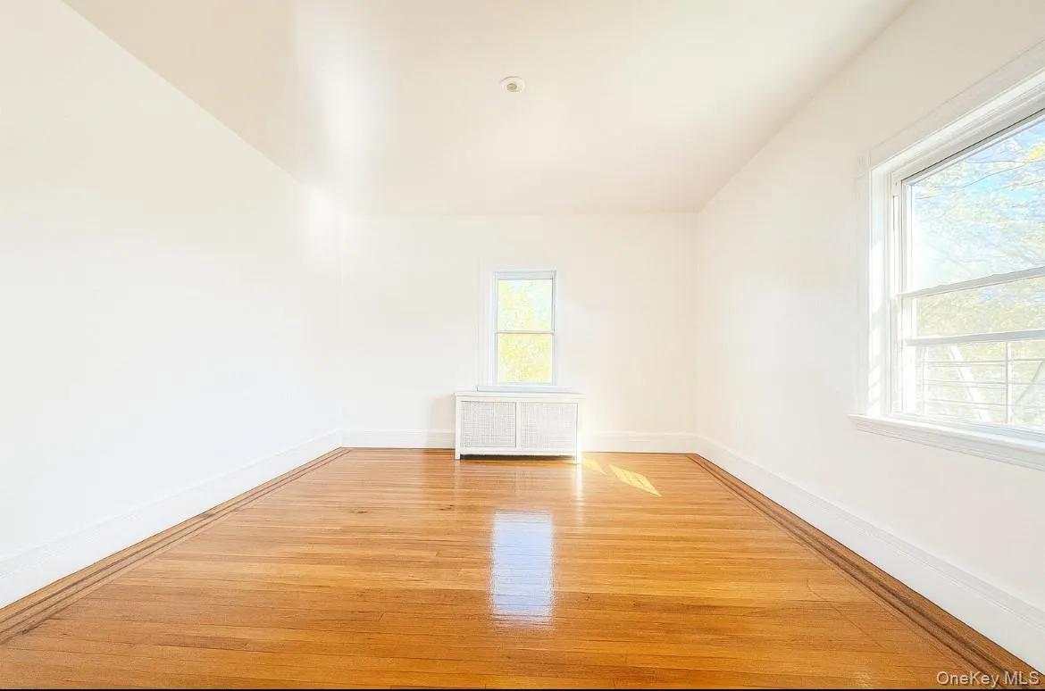 Empty room with radiator heating unit and light wood-type flooring Empty room with radiator heating unit and light wood-type flooring