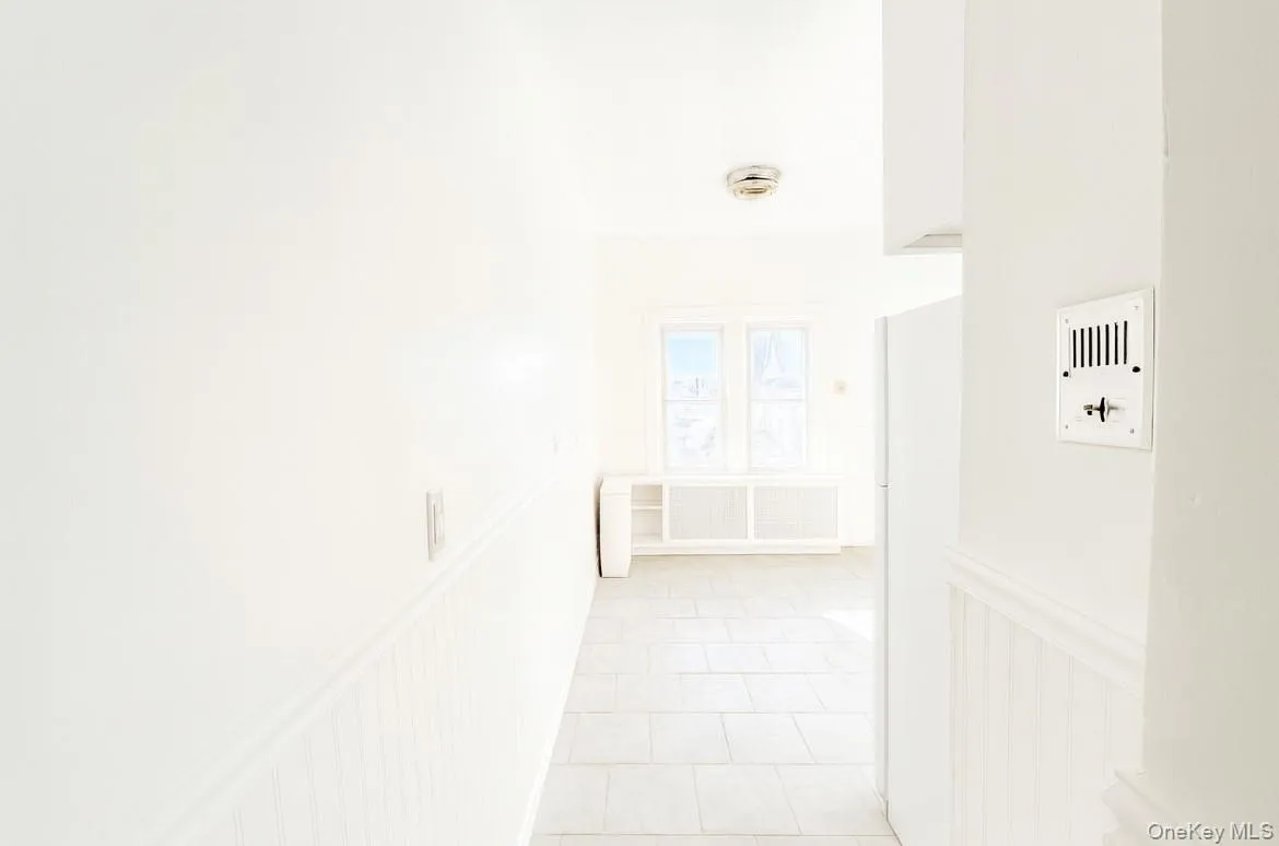 Corridor with light tile patterned floors and radiator Corridor with light tile patterned floors and radiator