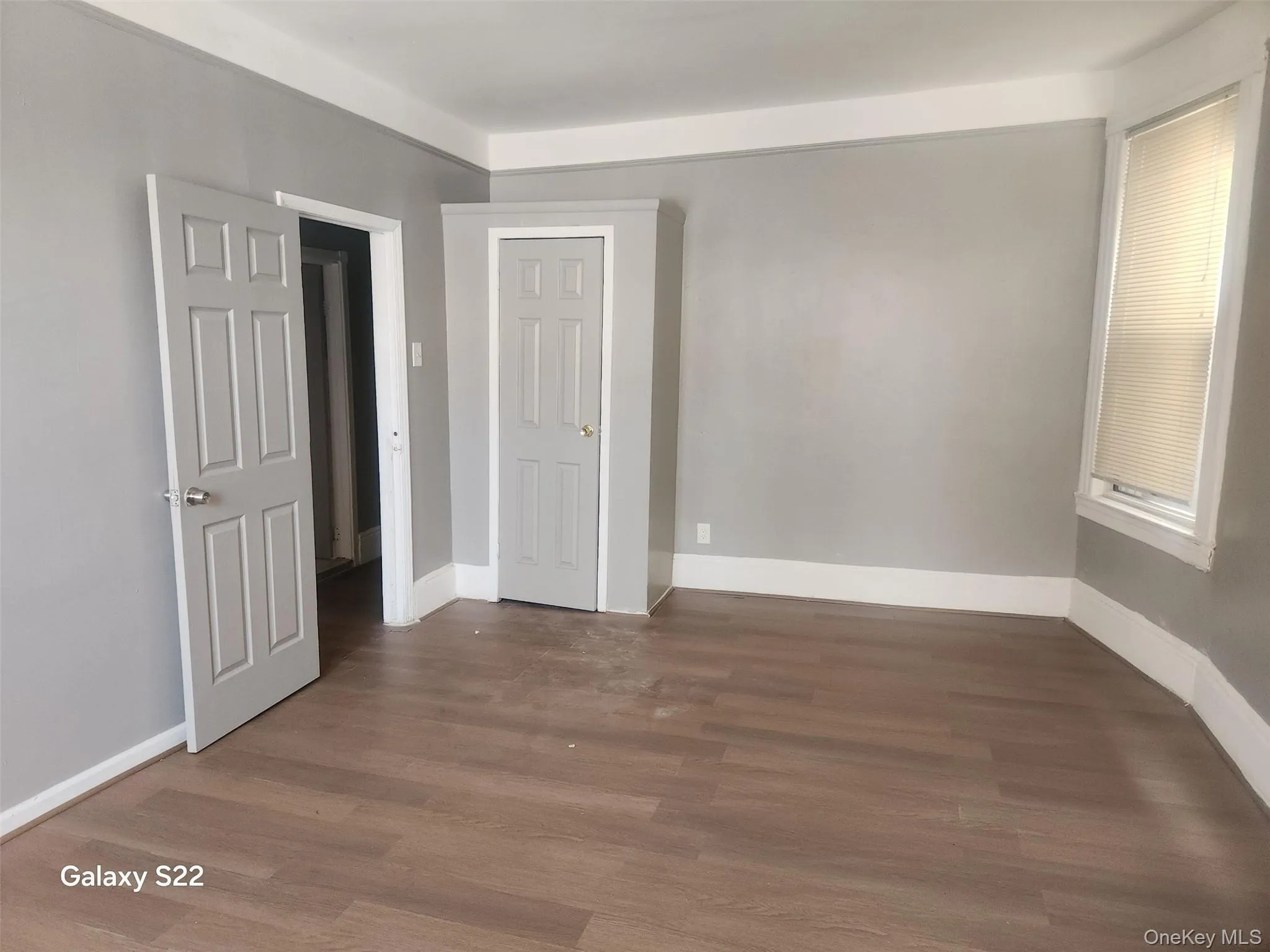 Unfurnished bedroom featuring dark wood finished floors and baseboards Unfurnished bedroom featuring dark wood finished floors and baseboards