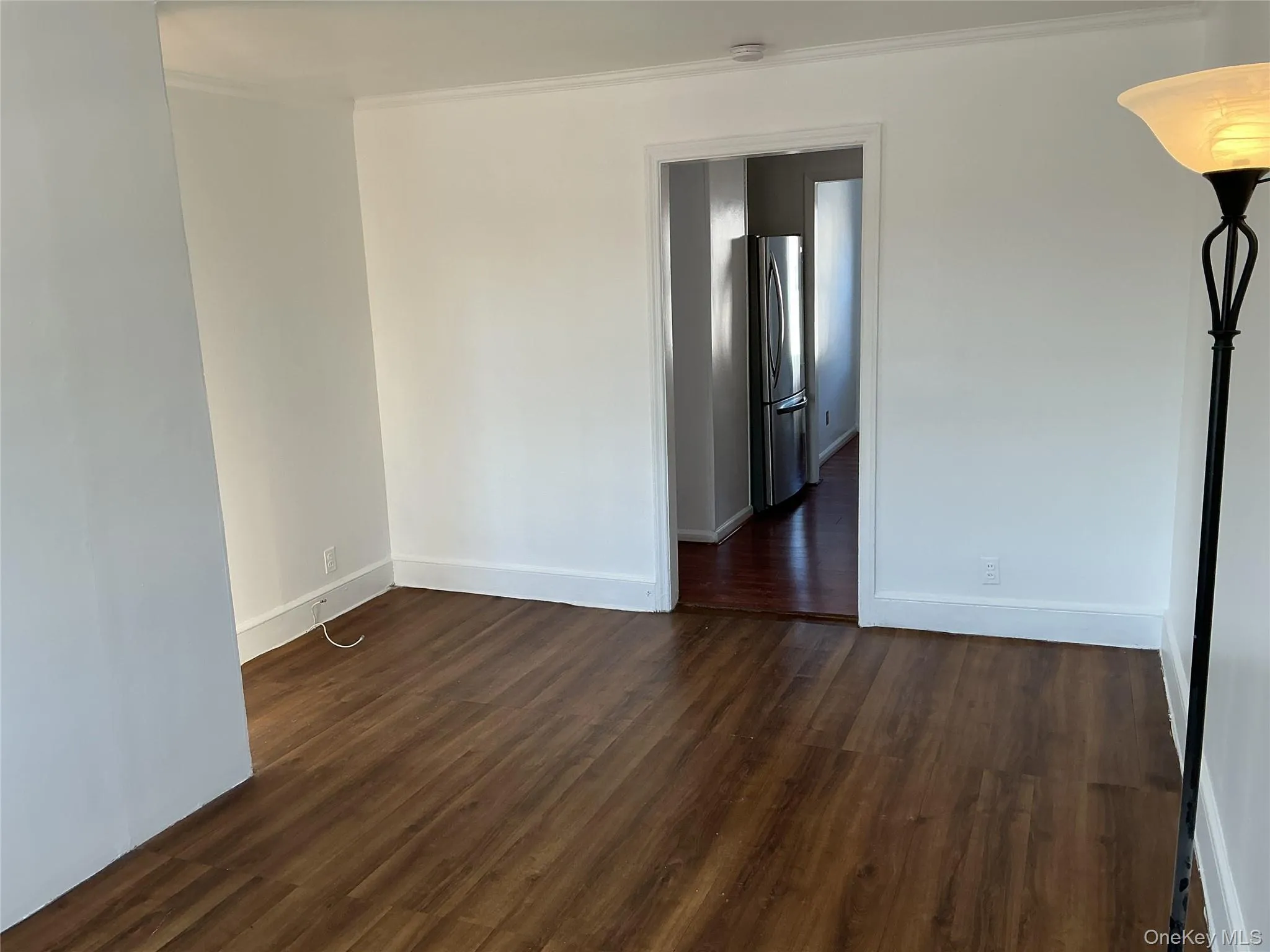 Empty room with dark wood-type flooring and crown molding Empty room with dark wood-type flooring and crown molding