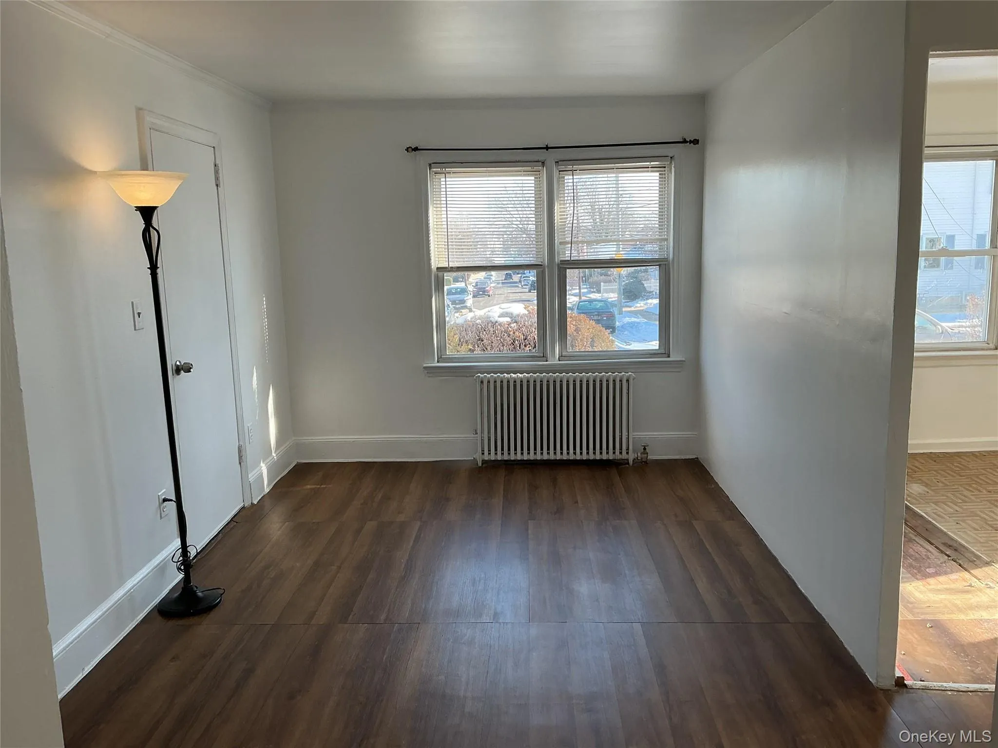 Spare room featuring radiator and dark wood-style flooring Spare room featuring radiator and dark wood-style flooring