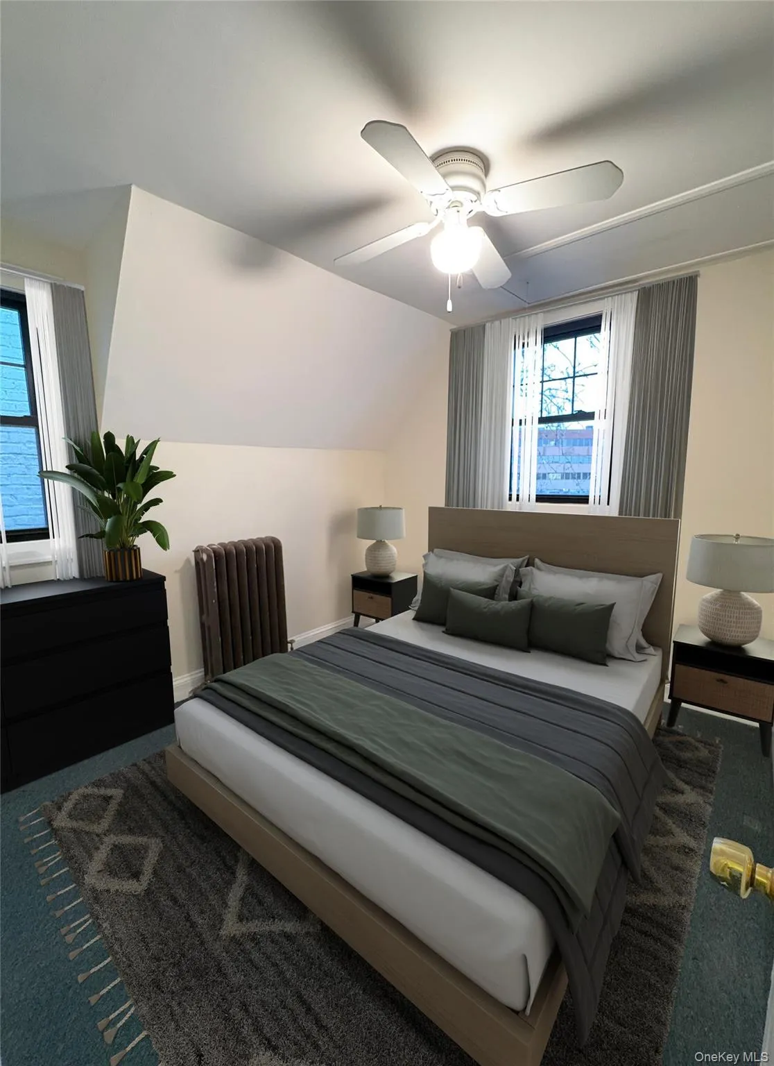 Bedroom featuring carpet floors, radiator heating unit, a ceiling fan, and lofted ceiling Bedroom featuring carpet floors, radiator heating unit, a ceiling fan, and lofted ceiling
