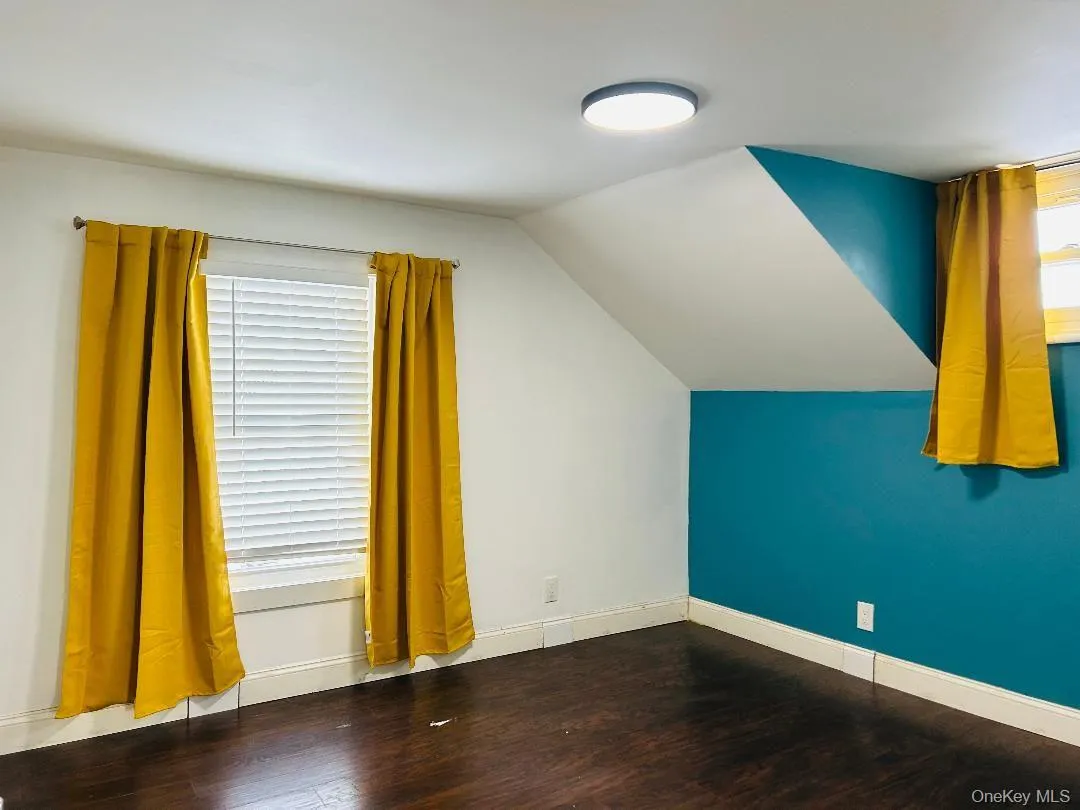 Bedroom with wood finished floors and lofted ceiling Bedroom with wood finished floors and lofted ceiling
