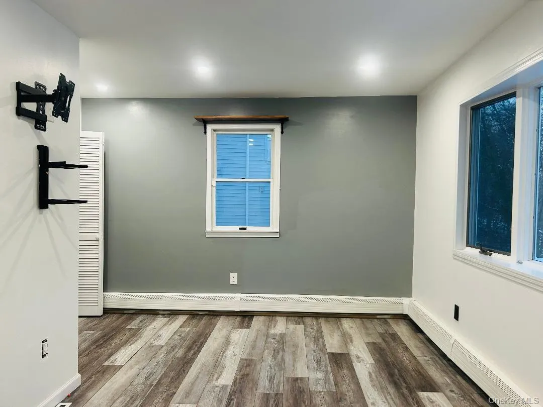 Bedroom featuring a baseboard radiator and wood finished floors Bedroom featuring a baseboard radiator and wood finished floors