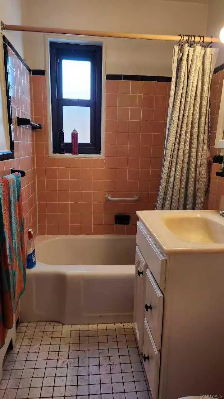 Bathroom featuring shower / bath combination with curtain, vanity, and light tile patterned floors Bathroom featuring shower / bath combination with curtain, vanity, and light tile patterned floors
