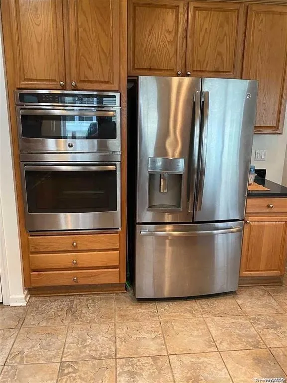 Kitchen featuring stainless steel appliances and brown cabinets Kitchen featuring stainless steel appliances and brown cabinets