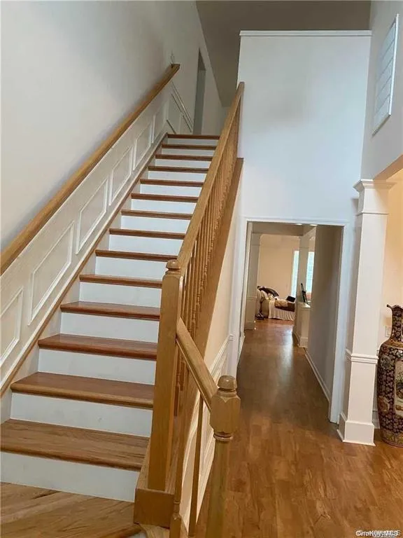 Stairway featuring wood finished floors and a towering ceiling Stairway featuring wood finished floors and a towering ceiling