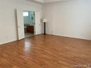 Unfurnished bedroom featuring dark wood-style flooring, ensuite bath, and crown molding Unfurnished bedroom featuring dark wood-style flooring, ensuite bath, and crown molding