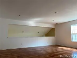 Empty room featuring dark wood-style floors and lofted ceiling Empty room featuring dark wood-style floors and lofted ceiling