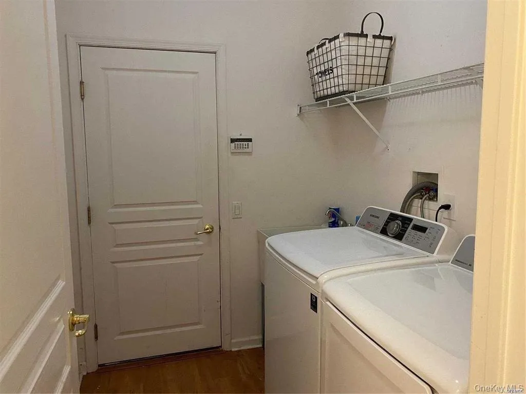Washroom with dark wood finished floors and washer and dryer Washroom with dark wood finished floors and washer and dryer