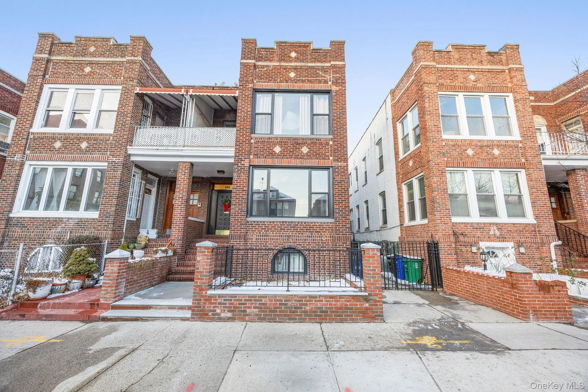 Traditional home featuring a balcony, brick siding, and a fenced front yard Traditional home featuring a balcony, brick siding, and a fenced front yard