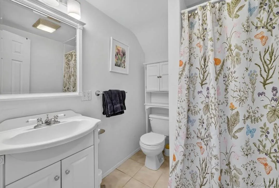 Bathroom featuring walk in shower, vanity, and light tile patterned flooring Bathroom featuring walk in shower, vanity, and light tile patterned flooring