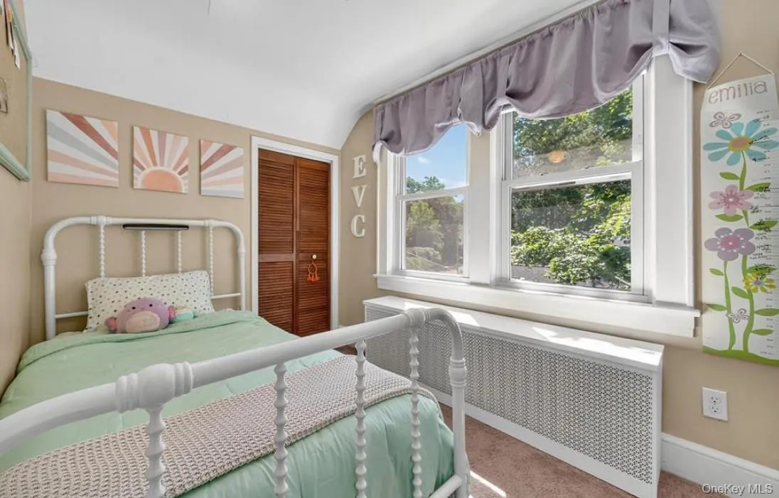 Second upstairs bedroom featuring a closet, wall of windows and vaulted ceiling Second upstairs bedroom featuring a closet, wall of windows and vaulted ceiling