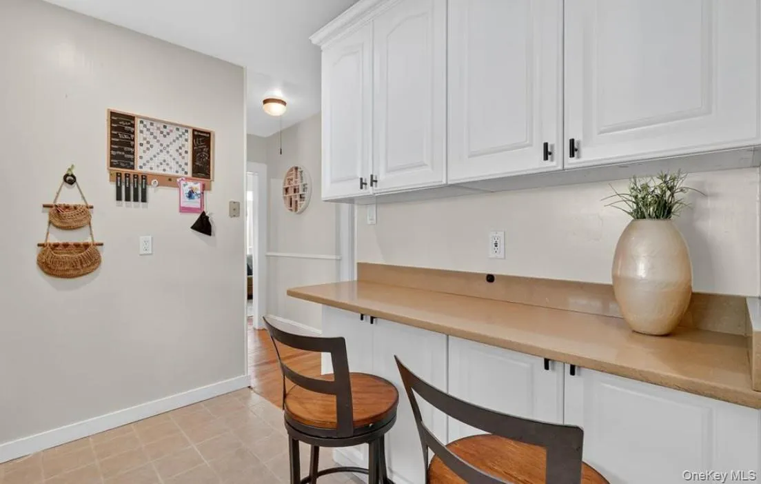 Bar area featuring white cabinets and light countertops Bar area featuring white cabinets and light countertops