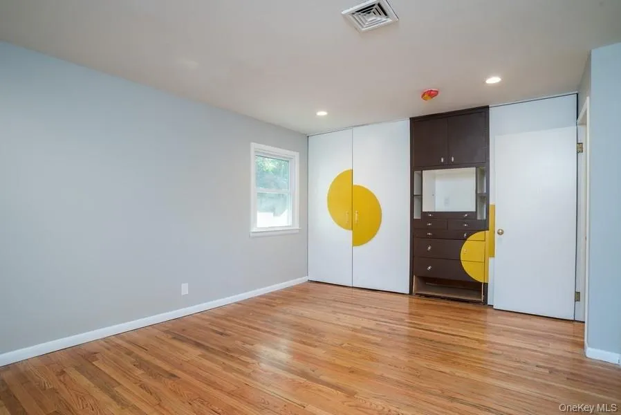 Unfurnished bedroom with light wood-style floors and recessed lighting Unfurnished bedroom with light wood-style floors and recessed lighting