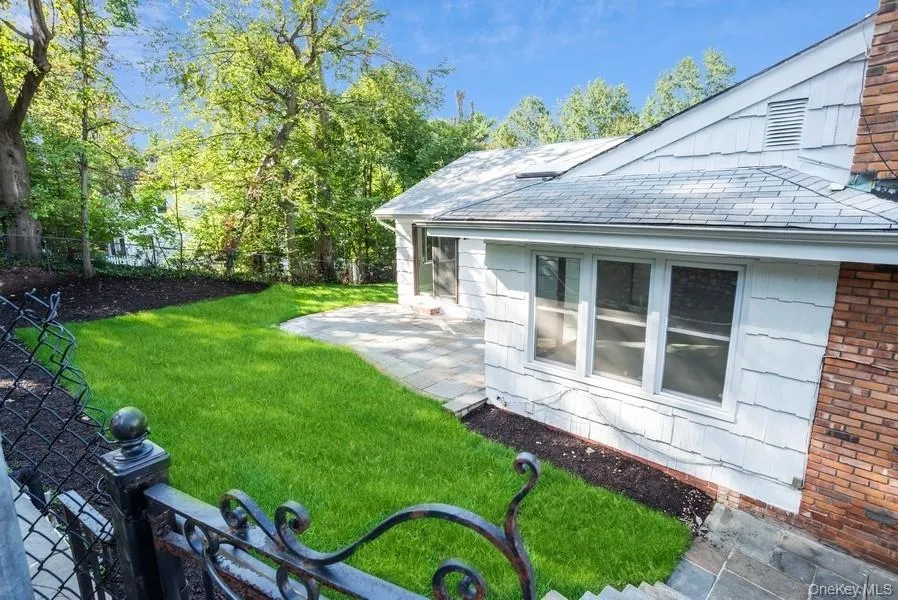 View of grassy yard featuring a patio area View of grassy yard featuring a patio area