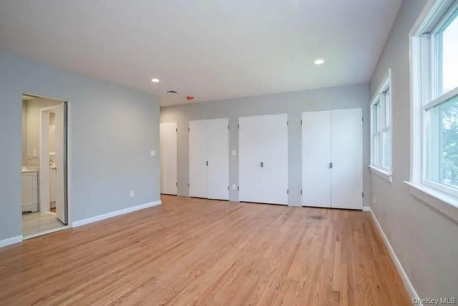 Unfurnished bedroom featuring two closets, light wood-style floors, connected bathroom, and recessed lighting Unfurnished bedroom featuring two closets, light wood-style floors, connected bathroom, and recessed lighting