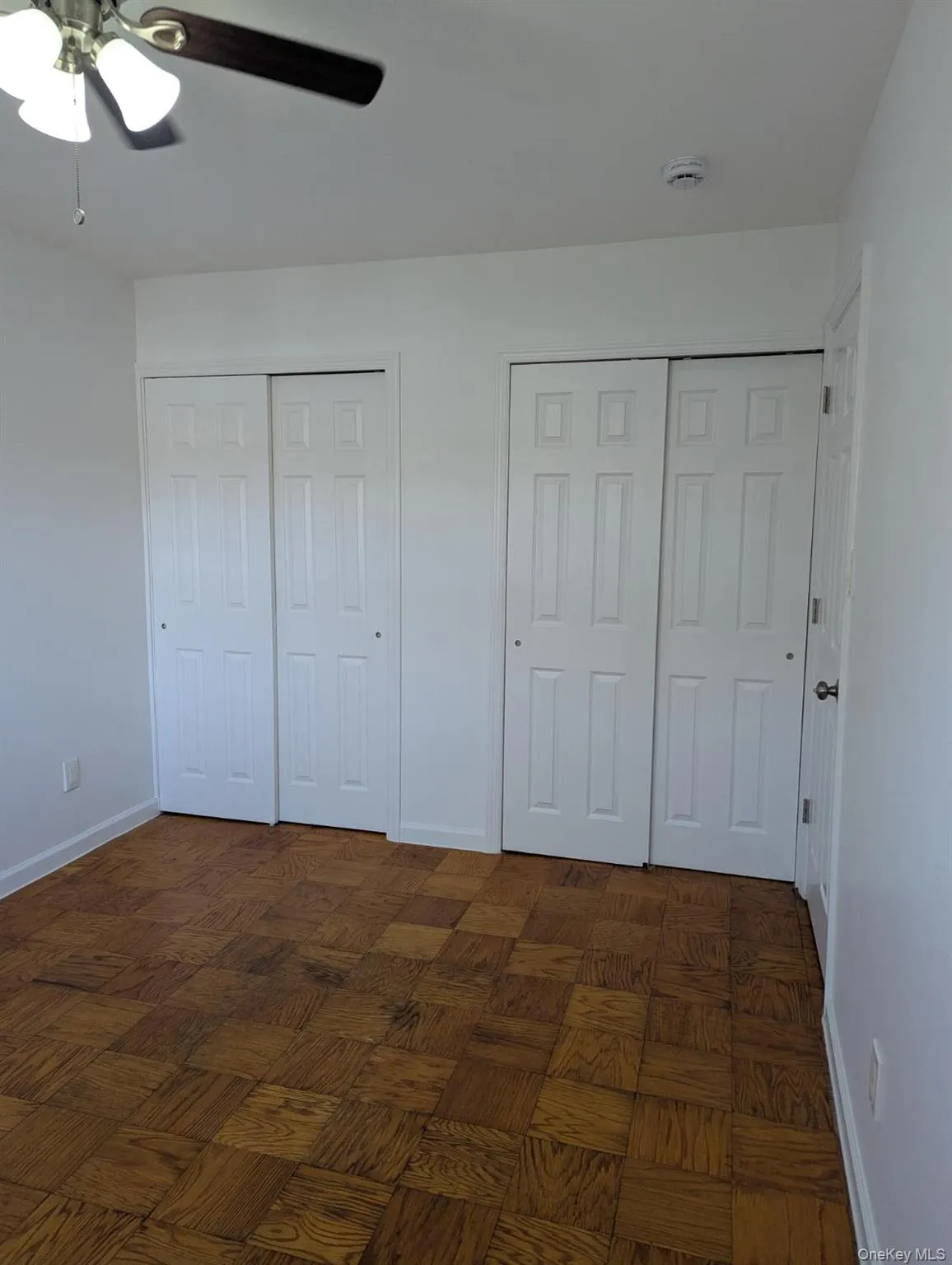 Unfurnished bedroom with two closets and a ceiling fan Unfurnished bedroom with two closets and a ceiling fan